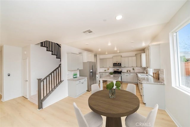 dining area with stairway, recessed lighting, light wood-style flooring, and visible vents