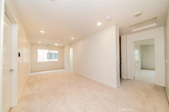 empty room with recessed lighting, light colored carpet, attic access, and baseboards