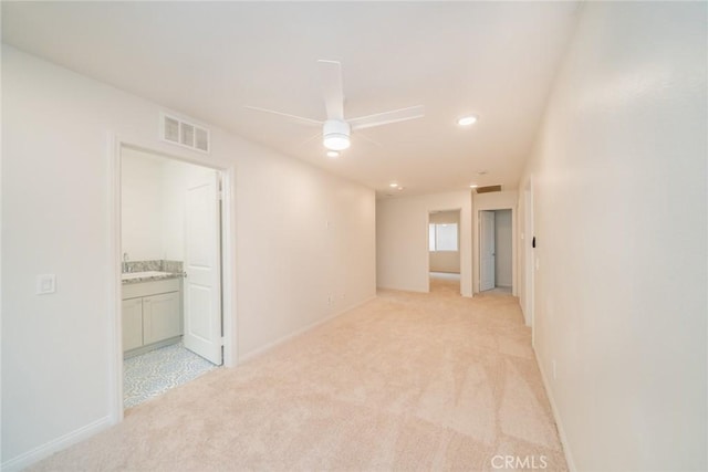 empty room with visible vents, light colored carpet, baseboards, and ceiling fan