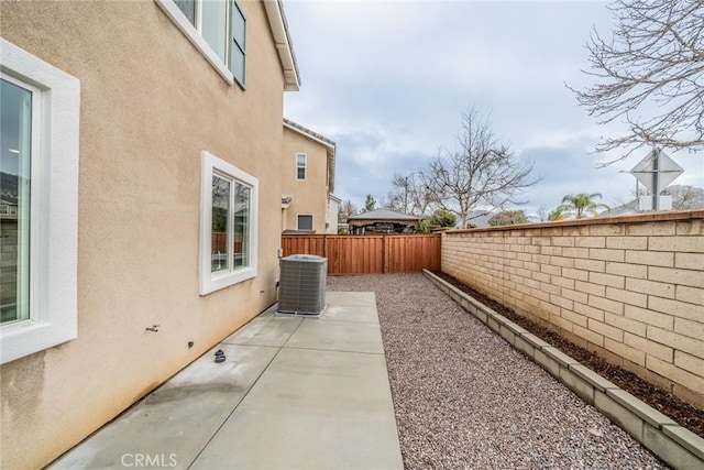 exterior space with a patio, cooling unit, a fenced backyard, and stucco siding