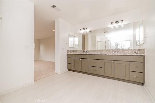 full bath featuring visible vents, a sink, walk in shower, and double vanity