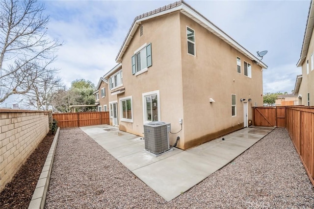 rear view of property featuring a patio, cooling unit, a fenced backyard, and stucco siding