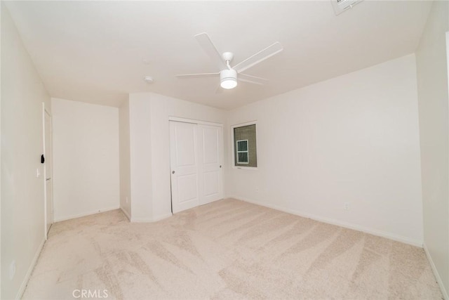 carpeted spare room featuring visible vents, baseboards, and ceiling fan