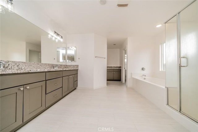 full bath featuring double vanity, a bath, a shower stall, and a sink