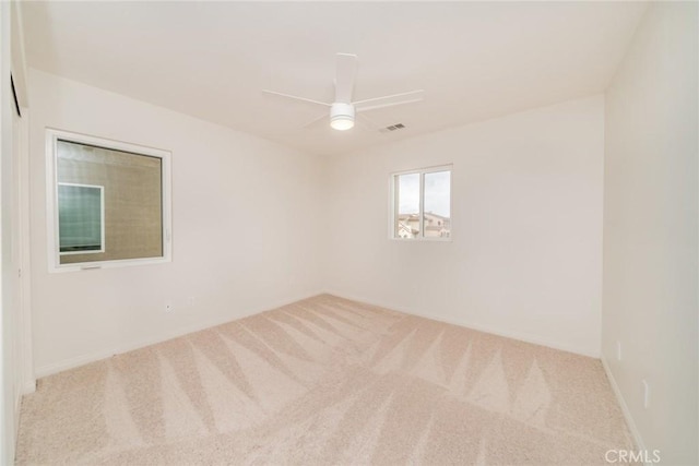 spare room with visible vents, a ceiling fan, and carpet