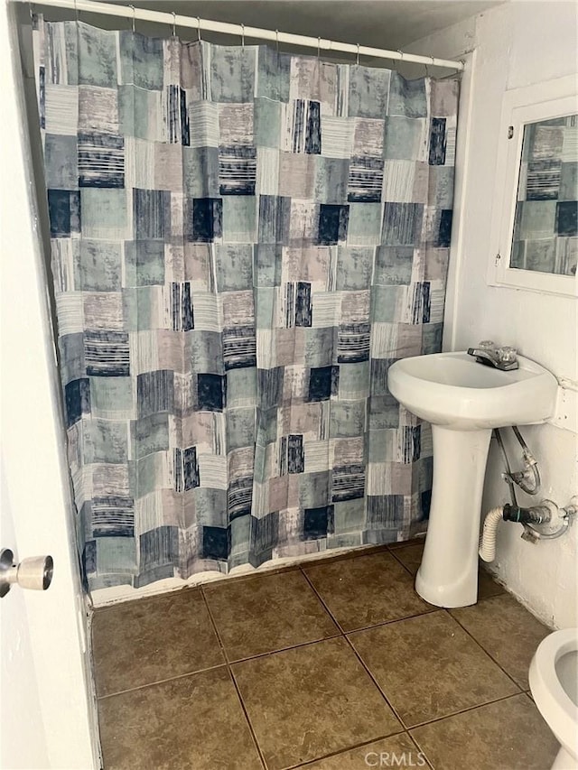 bathroom with tile patterned floors, a shower with curtain, and a sink