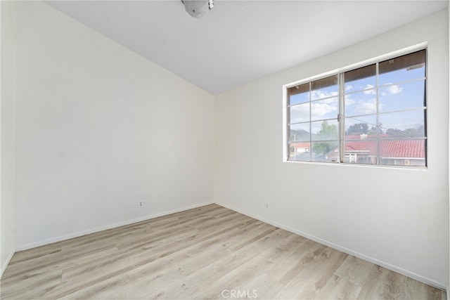 unfurnished room featuring baseboards and light wood finished floors