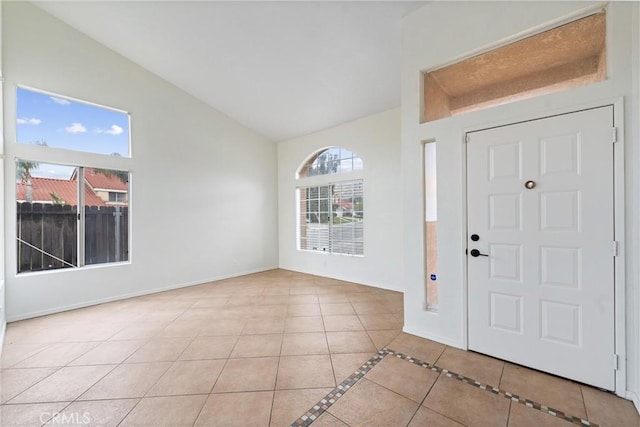 tiled entrance foyer featuring high vaulted ceiling and baseboards