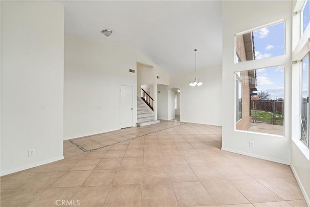 spare room featuring light tile patterned floors, baseboards, high vaulted ceiling, an inviting chandelier, and stairs