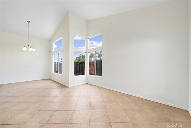 spare room with light tile patterned floors, baseboards, high vaulted ceiling, and an inviting chandelier