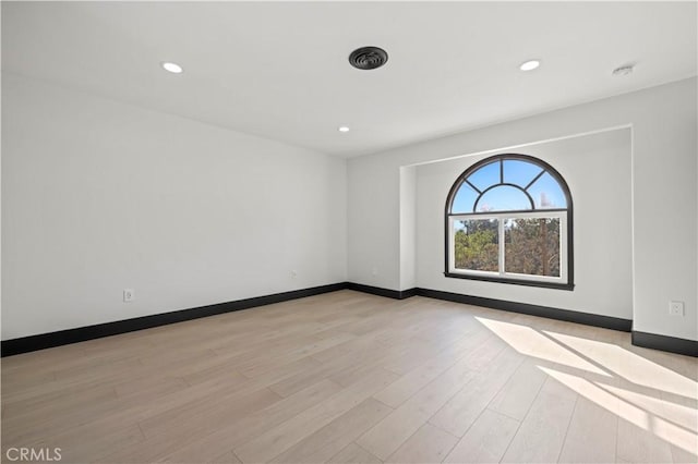 spare room featuring recessed lighting, light wood-style flooring, and baseboards