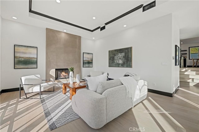 living area with recessed lighting, a fireplace, and baseboards