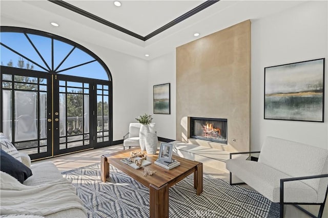 living room with ornamental molding, recessed lighting, french doors, and a large fireplace