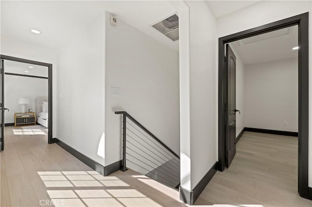 corridor with visible vents, an upstairs landing, light wood-style flooring, recessed lighting, and baseboards