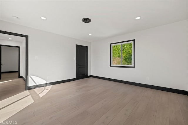 unfurnished room featuring recessed lighting, light wood-type flooring, and baseboards