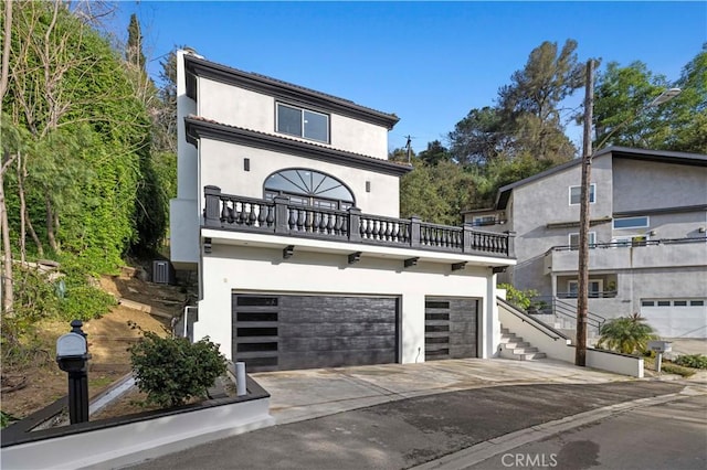 view of front of home featuring an attached garage, driveway, and stucco siding