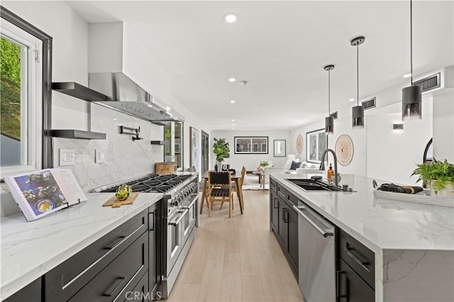 kitchen featuring visible vents, a sink, decorative backsplash, appliances with stainless steel finishes, and dark cabinets