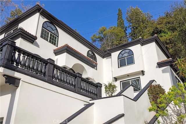 view of home's exterior featuring a balcony and stucco siding