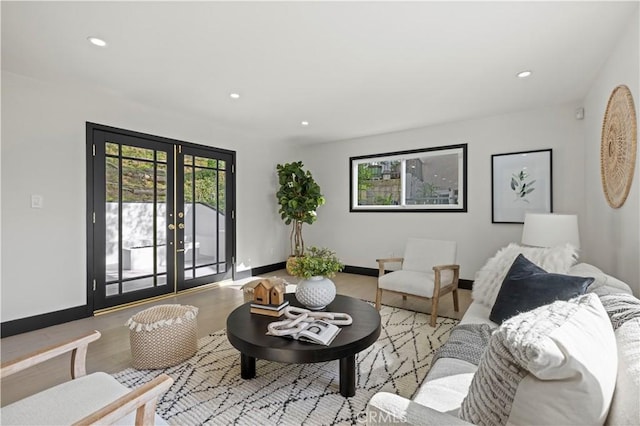 living area with recessed lighting, french doors, baseboards, and wood finished floors