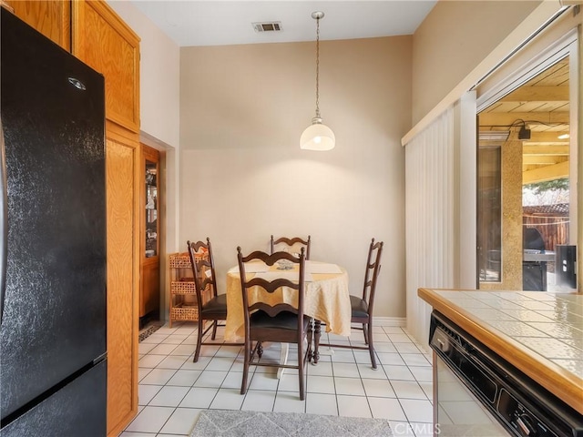 dining space featuring light tile patterned floors and visible vents