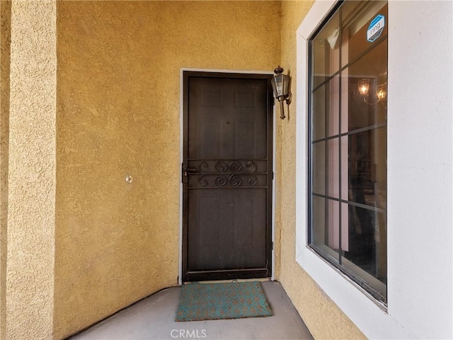 property entrance with stucco siding