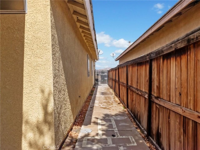 view of side of property featuring stucco siding and fence