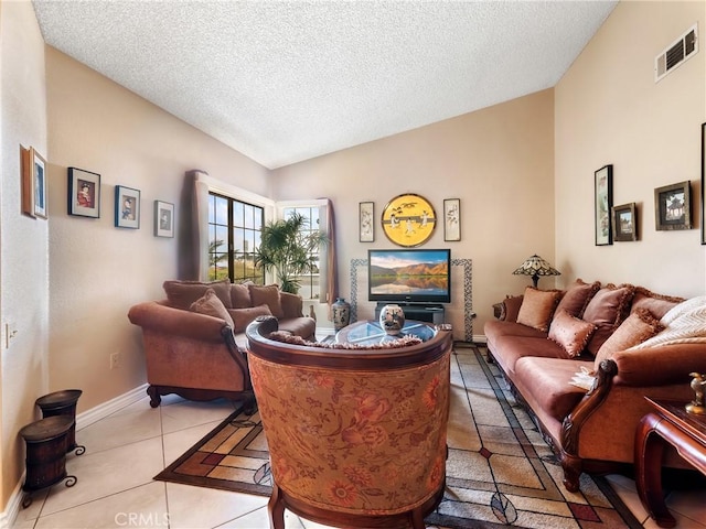 living area with light tile patterned flooring, visible vents, a textured ceiling, and lofted ceiling