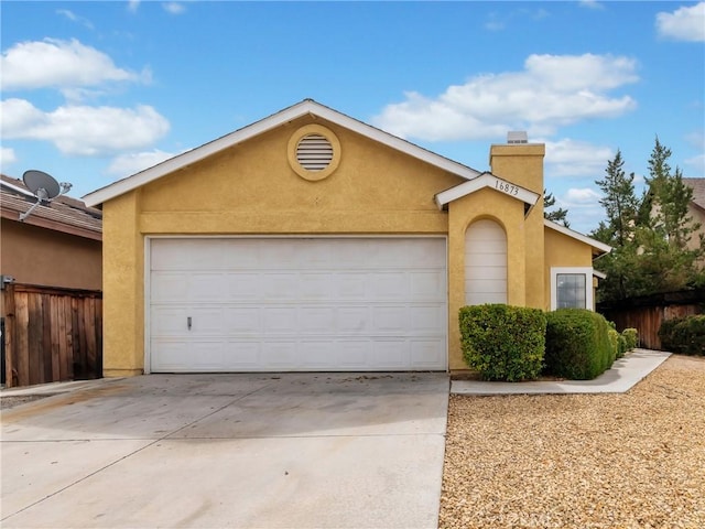 view of front of house featuring fence, stucco siding, a chimney, a garage, and driveway