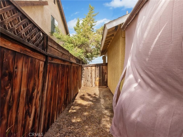 view of side of property with fence and stucco siding