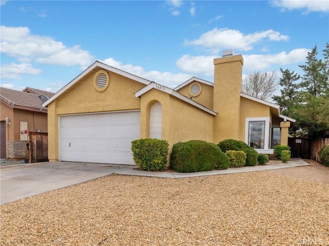 view of front of house featuring fence, concrete driveway, stucco siding, a chimney, and an attached garage