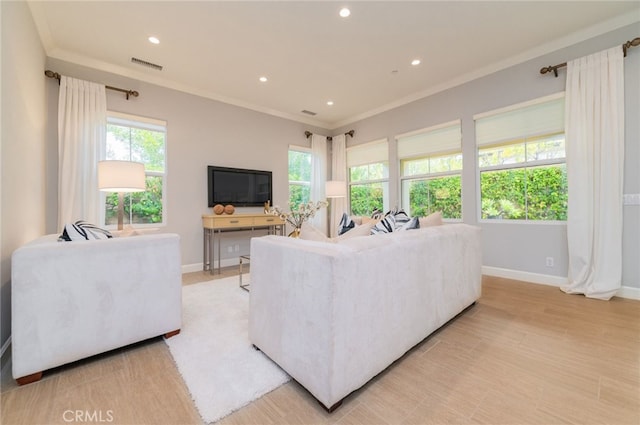 living room featuring baseboards, visible vents, a wealth of natural light, and ornamental molding