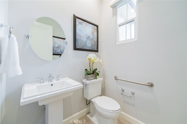 bathroom with toilet and baseboards