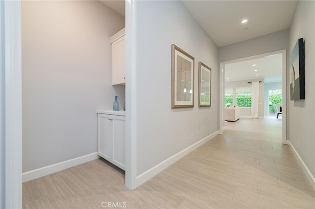 hallway with recessed lighting and baseboards