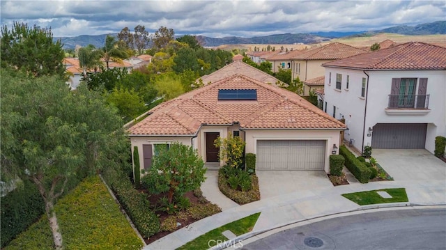 mediterranean / spanish house with stucco siding, concrete driveway, and a tile roof