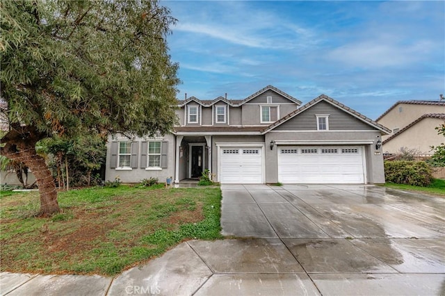 view of front of property with stucco siding, concrete driveway, an attached garage, a front yard, and a tiled roof