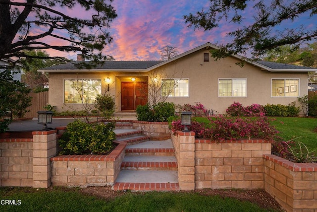 ranch-style home featuring stucco siding and a chimney