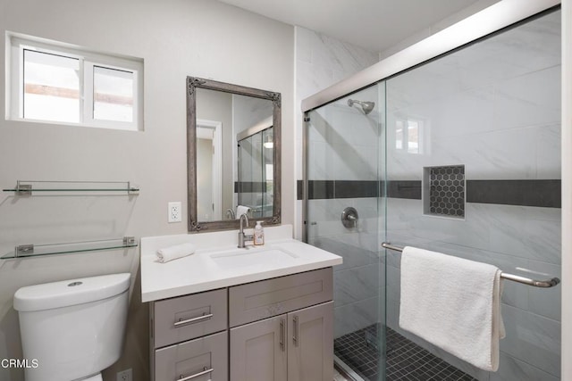 full bathroom featuring toilet, a stall shower, and vanity