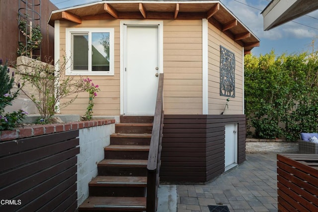 view of exterior entry with a patio