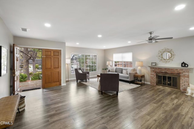 living room with visible vents, a ceiling fan, wood finished floors, recessed lighting, and a brick fireplace