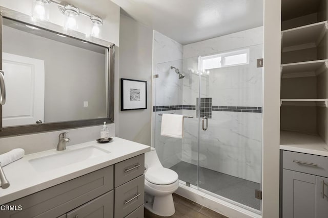 bathroom with vanity, toilet, and a shower stall