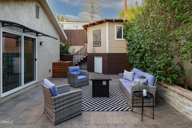 view of patio / terrace with an outdoor hangout area, stairs, and fence