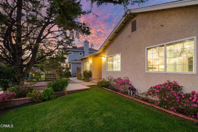 yard at dusk featuring a patio area