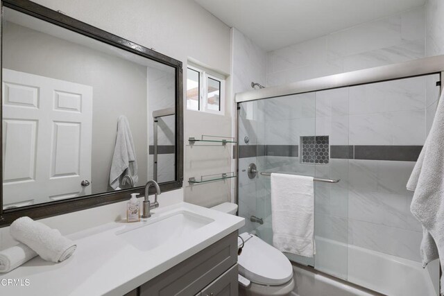 full bathroom with toilet, vanity, and shower / bath combination with glass door