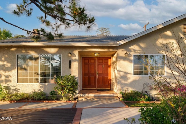 entrance to property featuring stucco siding