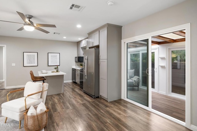 kitchen featuring visible vents, gray cabinets, freestanding refrigerator, and dark wood-type flooring