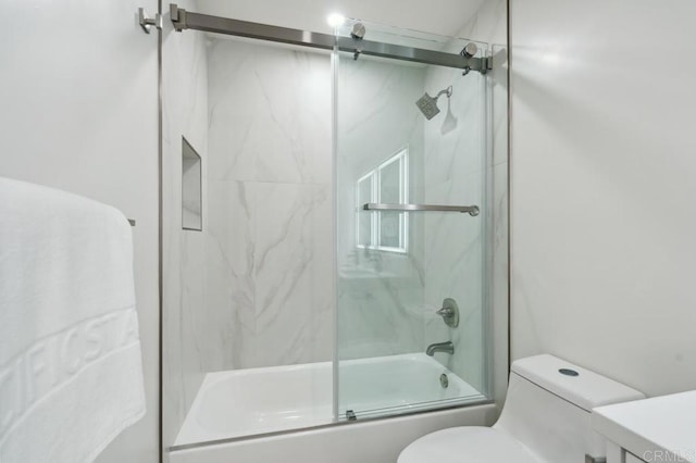 full bathroom featuring toilet, vanity, and bath / shower combo with glass door