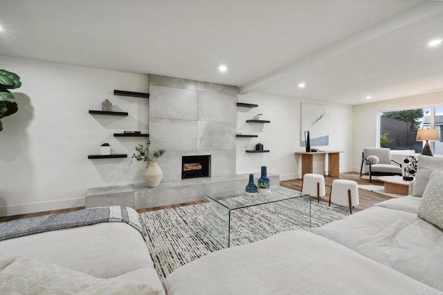 living area featuring recessed lighting, a tile fireplace, baseboards, and wood finished floors