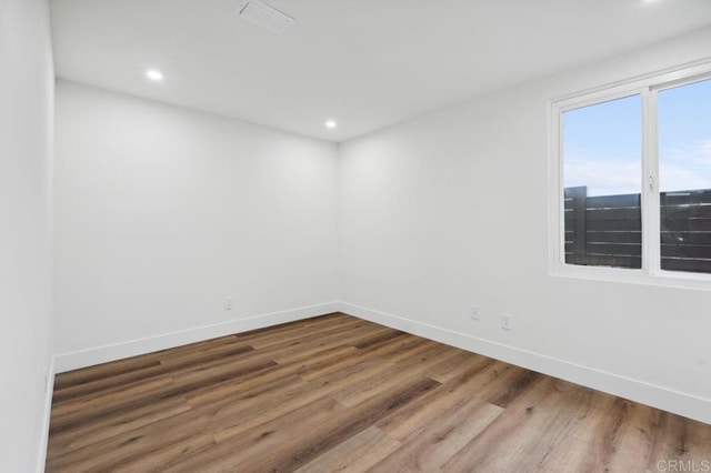 unfurnished room with recessed lighting, baseboards, and wood finished floors