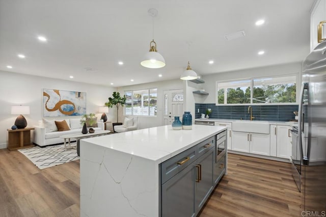 kitchen featuring gray cabinets, stainless steel appliances, dark wood-style floors, white cabinetry, and a sink