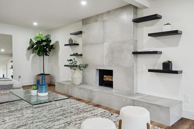 living room with a fireplace, recessed lighting, wood finished floors, and baseboards